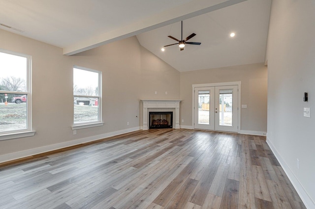 unfurnished living room featuring ceiling fan, french doors, high vaulted ceiling, beamed ceiling, and light wood-type flooring