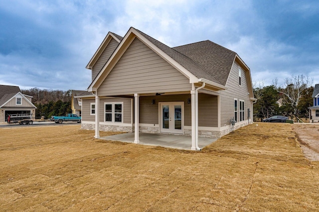 back of house featuring french doors, a patio area, and a lawn