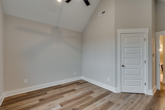 spare room with ceiling fan, lofted ceiling, and light wood-type flooring