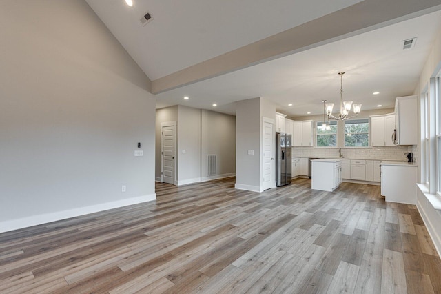 kitchen with white cabinetry, an inviting chandelier, stainless steel fridge with ice dispenser, light hardwood / wood-style floors, and a kitchen island