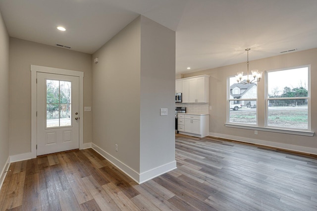 foyer featuring a chandelier and light hardwood / wood-style floors