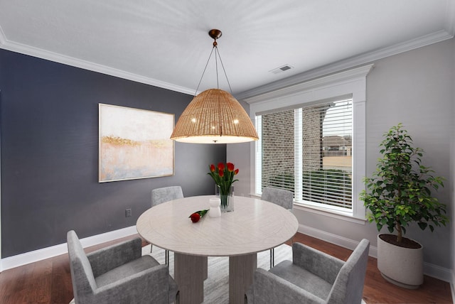 dining space with hardwood / wood-style floors and crown molding