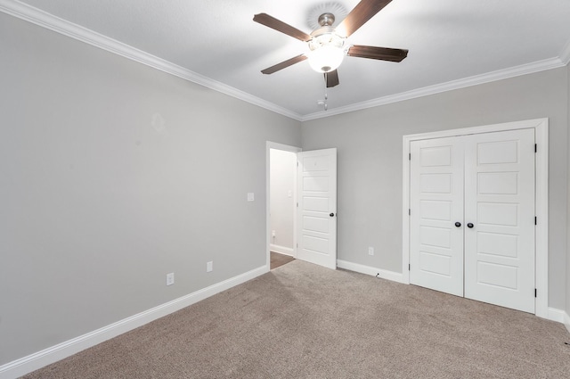 unfurnished bedroom with crown molding, carpet floors, a closet, and ceiling fan