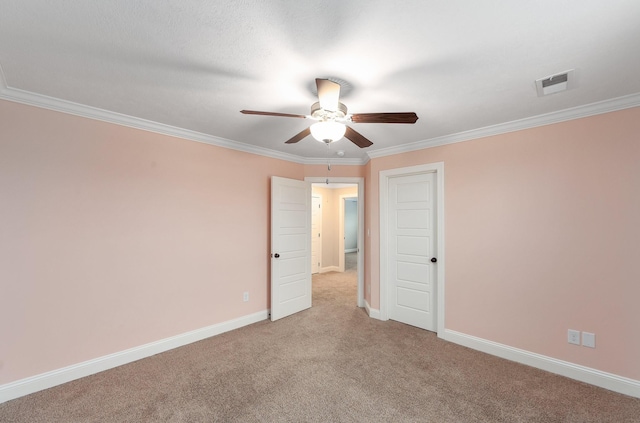 carpeted spare room featuring crown molding and ceiling fan