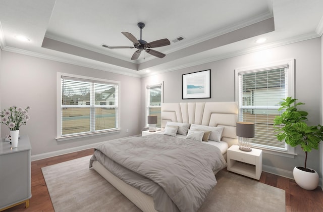 bedroom with dark wood-type flooring, ceiling fan, crown molding, and a raised ceiling