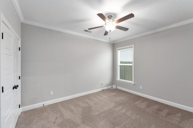 spare room featuring crown molding, ceiling fan, and carpet