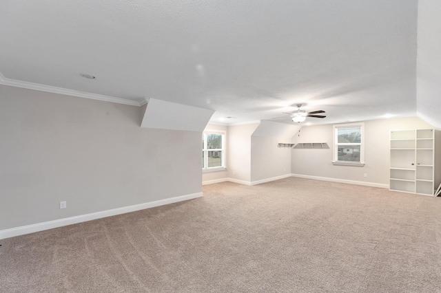 interior space with vaulted ceiling, crown molding, a wealth of natural light, and ceiling fan