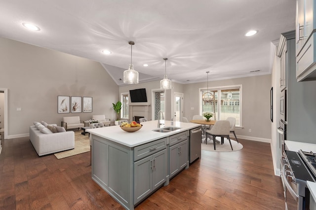 kitchen with pendant lighting, sink, appliances with stainless steel finishes, gray cabinetry, and a center island with sink