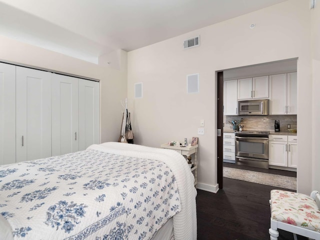 bedroom with dark hardwood / wood-style flooring and a closet