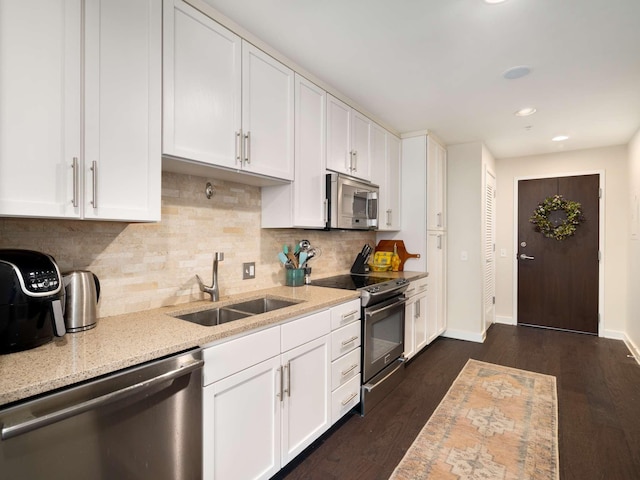 kitchen featuring light stone countertops, white cabinetry, sink, and stainless steel appliances