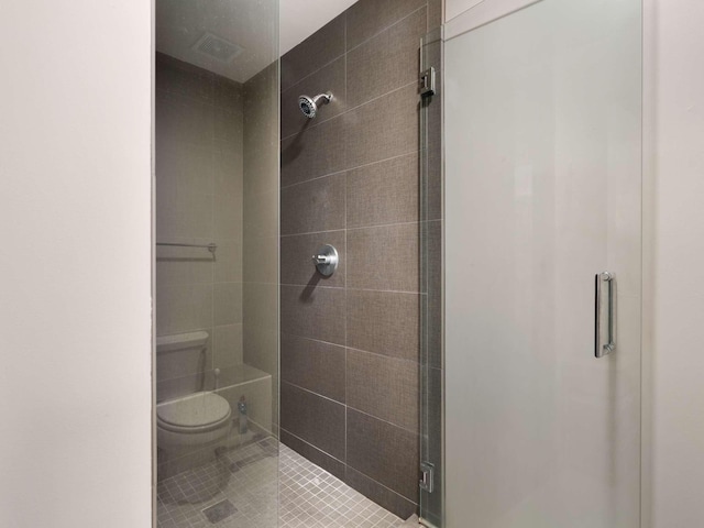 bathroom featuring tile patterned flooring, toilet, and walk in shower