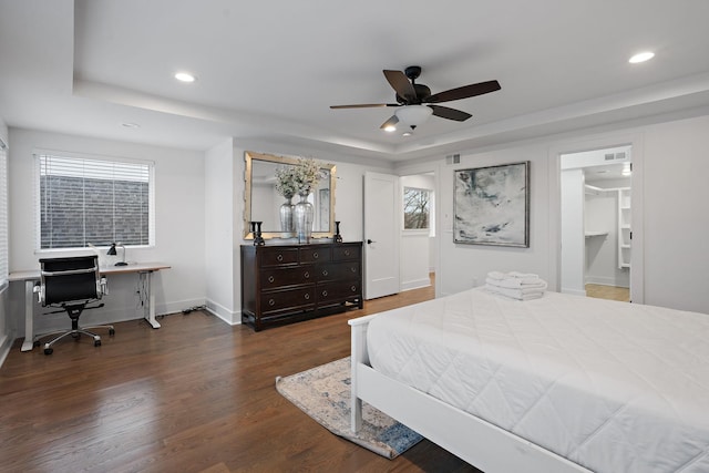 bedroom featuring ceiling fan, a tray ceiling, and dark hardwood / wood-style floors