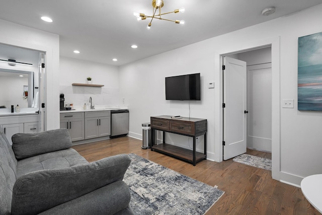 living room featuring sink, a chandelier, and dark wood-type flooring