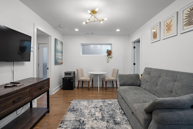 living room with an inviting chandelier and dark wood-type flooring