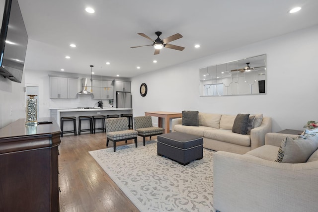 living room featuring wood-type flooring and ceiling fan