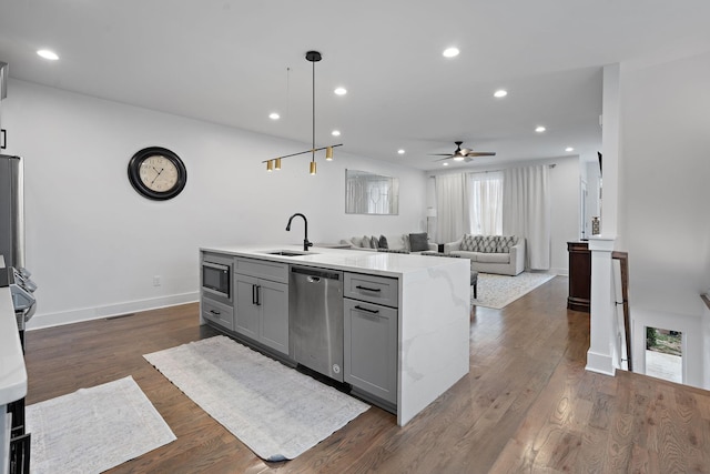 kitchen featuring decorative light fixtures, stainless steel appliances, gray cabinets, ceiling fan, and sink