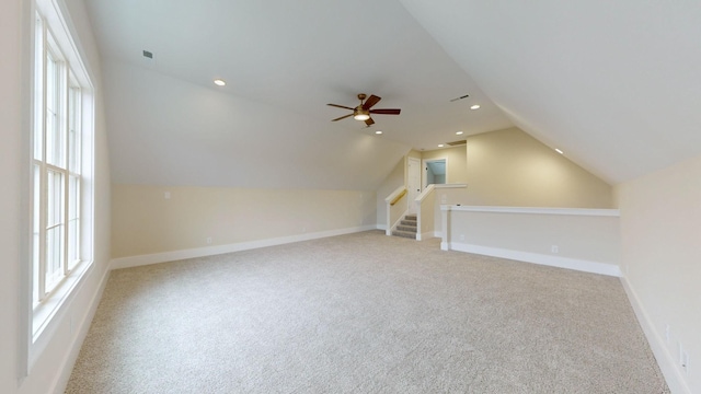 additional living space with ceiling fan, light colored carpet, and lofted ceiling