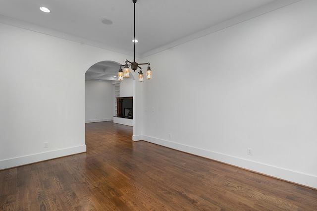 spare room with ornamental molding and dark wood-type flooring