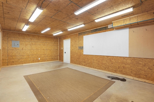 garage with electric panel and wooden walls