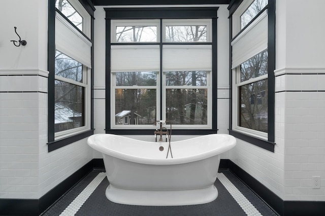 bathroom with tile patterned floors and a tub