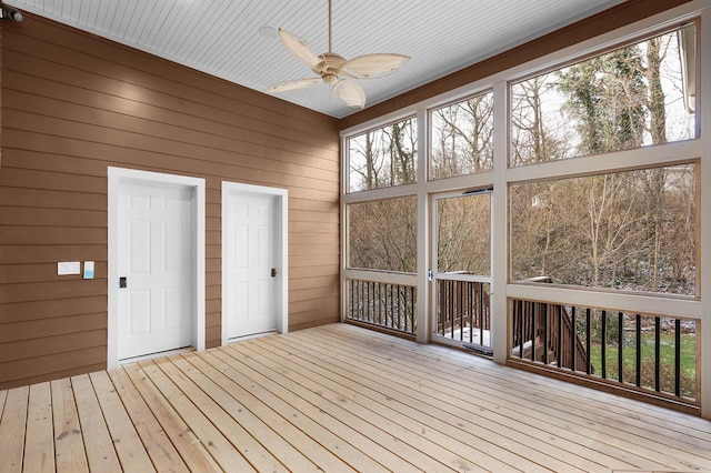 unfurnished sunroom with ceiling fan