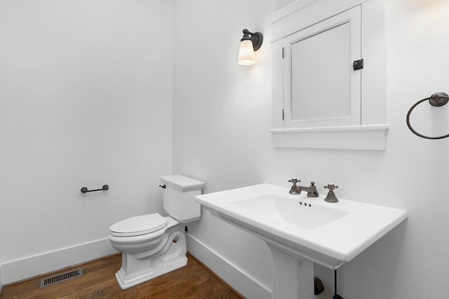 bathroom featuring hardwood / wood-style flooring and toilet