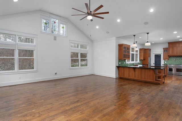 kitchen with tasteful backsplash, ceiling fan, dark wood-type flooring, double oven range, and hanging light fixtures