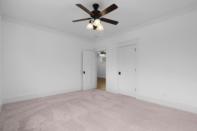 carpeted empty room with ceiling fan and ornamental molding