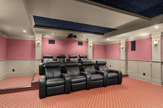 carpeted cinema room featuring beamed ceiling and ornamental molding