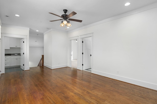 empty room featuring ceiling fan, dark hardwood / wood-style flooring, ornamental molding, and sink