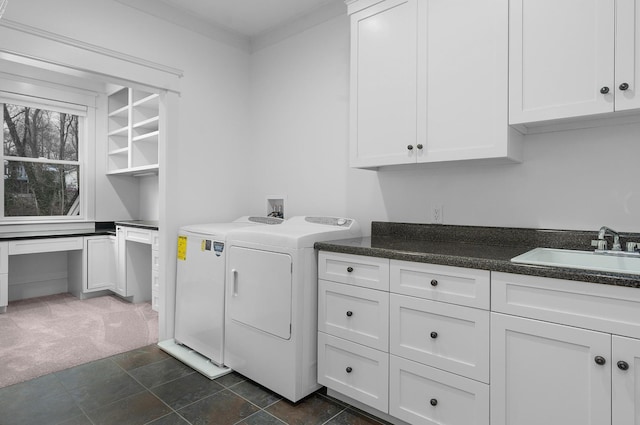 clothes washing area with washing machine and clothes dryer, sink, cabinets, and dark colored carpet