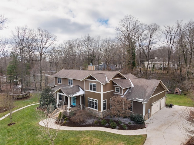 craftsman inspired home with a garage and a front lawn