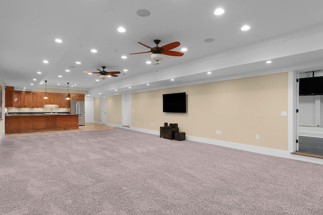 unfurnished living room with ceiling fan and light colored carpet