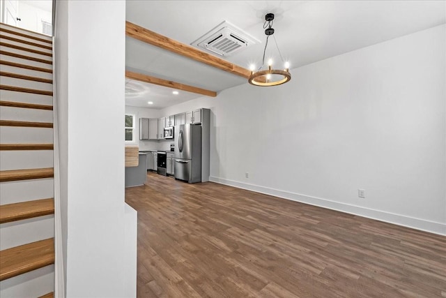 unfurnished living room with beamed ceiling, wood-type flooring, and a notable chandelier