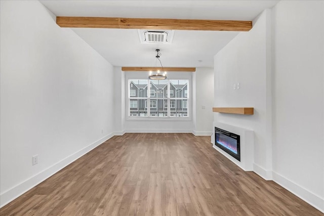 unfurnished living room with beamed ceiling, a notable chandelier, and hardwood / wood-style flooring