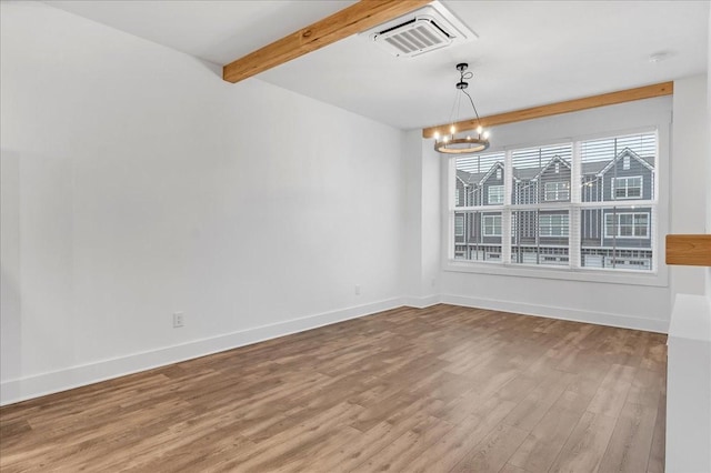 empty room with beam ceiling, a chandelier, and wood-type flooring