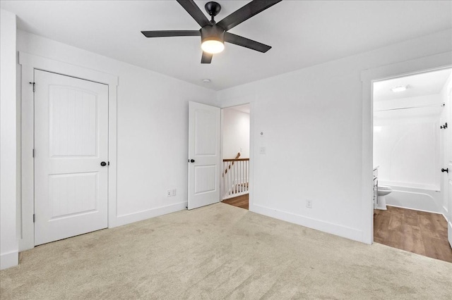 unfurnished bedroom featuring carpet flooring, ensuite bath, a closet, and ceiling fan