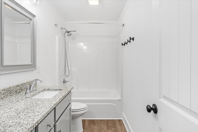 full bathroom featuring shower / tub combination, vanity, hardwood / wood-style flooring, and toilet