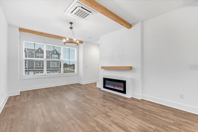 unfurnished living room featuring beam ceiling, light hardwood / wood-style floors, and a notable chandelier