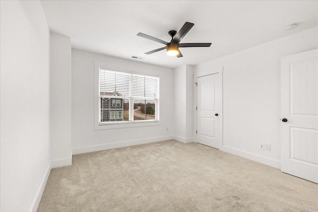 carpeted spare room featuring ceiling fan