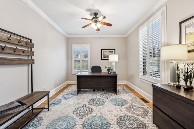 office area with light wood-type flooring, ceiling fan, and ornamental molding