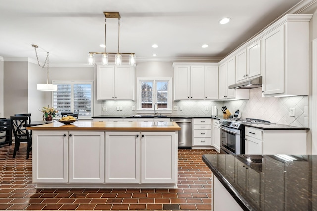 kitchen with white cabinets, sink, decorative light fixtures, butcher block counters, and stainless steel appliances