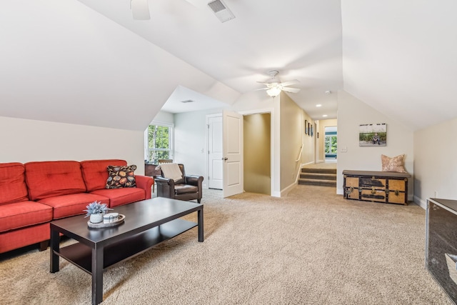 living room featuring ceiling fan, light carpet, and vaulted ceiling