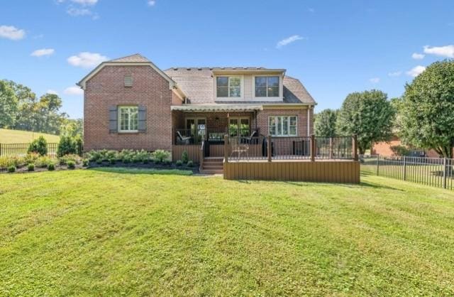 rear view of property with a yard and a deck