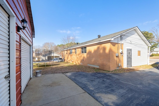 view of side of home with a patio and a trampoline