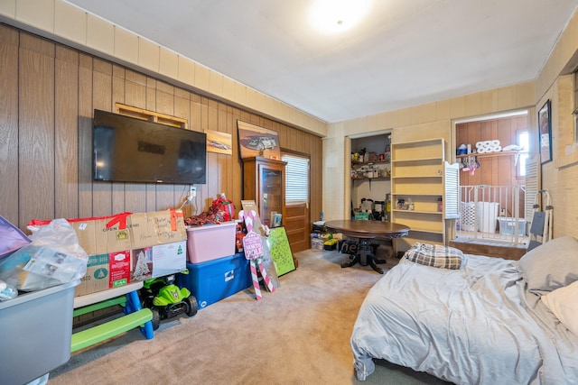 carpeted bedroom featuring wood walls