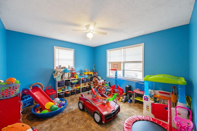 game room featuring plenty of natural light, ceiling fan, and carpet floors