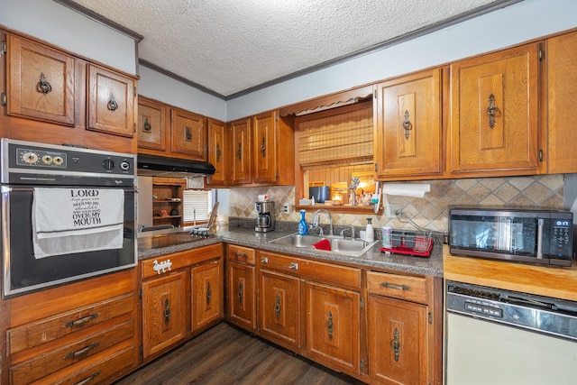 kitchen with sink, dark wood-type flooring, crown molding, a textured ceiling, and black appliances