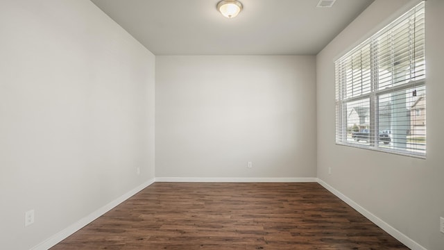 unfurnished room with dark wood-type flooring