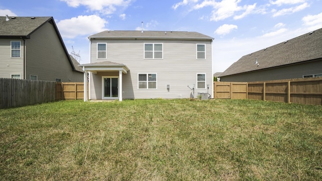 rear view of house featuring a yard